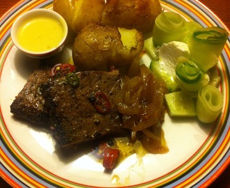 Steak af en slags med ovnbagte knuste kartofler, karameliseret løg i sukker og æblecidereddike, serveret med hollandaise og agurk i tykmælk.