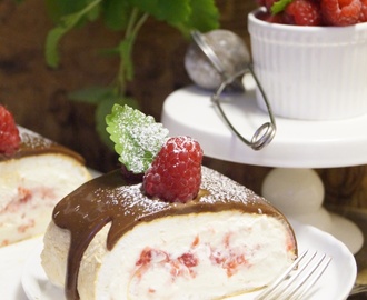 Pavlova-Rulltårta med hallon och vaniljswirl toppad med mjölkchoklad-ganasch.
