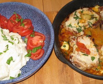 Fläskkotlett på en bädd av tomat och squash med basilikamos.