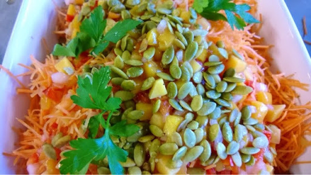 Gulerodssalat med mangosalsa og salt bagt græskarkerner .