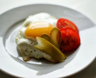 Søndagsmorgenmad: sennepssmurt rugbrød med salami, spejlæg, tomat og drueagurk