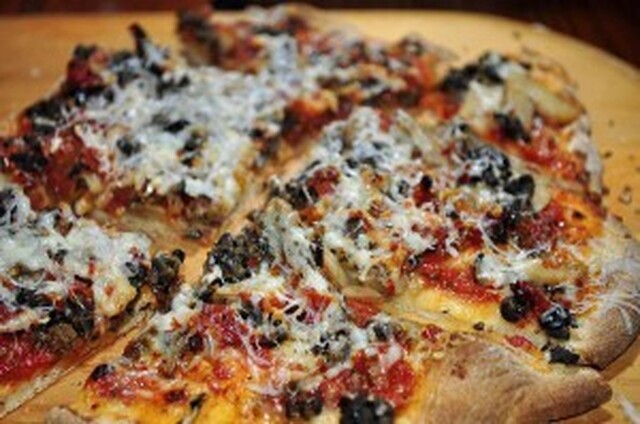 Hjemmelaget pizza med oliven og tomat