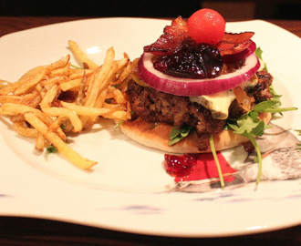 Hjemmelaget hamburger med blåmuggost, karamellisert løk, dulcitatomat, rødløk, ripsbærgele og pommes frites.