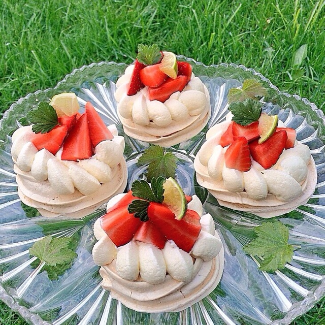Mini pavlova med vanilj-marinerade rabarber lättvispad grädde och färska jordgubbar.