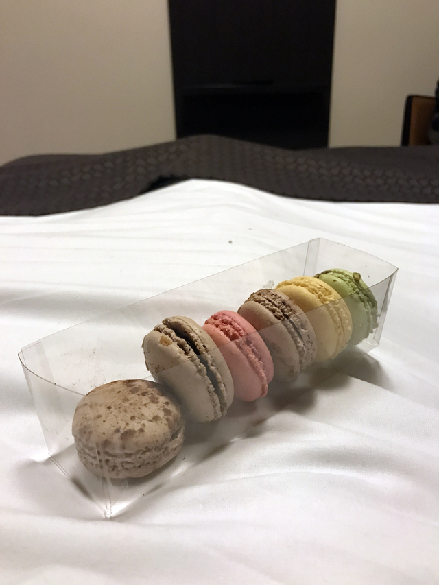 Macarons från Leonidas i en fluffig hotellsäng