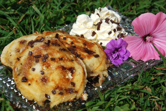 White and light chocolate chip pancakes with cinnamon cream and maple syrup