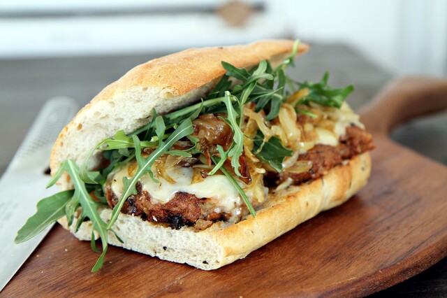 Ciabatta med hamburgare och smält ost, karamelliserad lök och ruccola