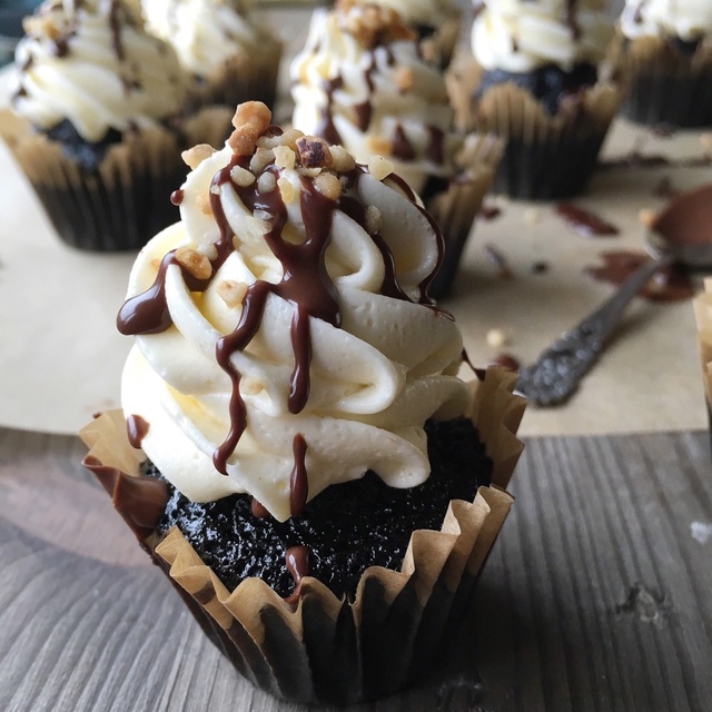 Black chocolate cupcakes with vanilla frosting and hazelnut crunch
