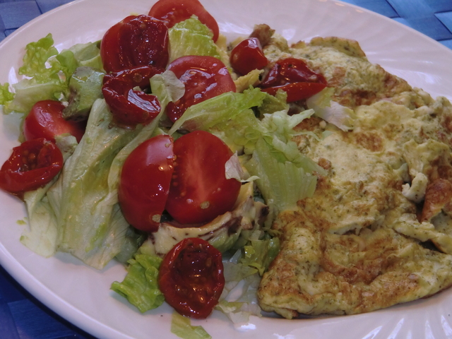 Latlunch med örtig omelett och sallad på avocado, och soltorkade körsbärstomater