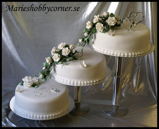 Bröllopstårta med vita rosbuketter