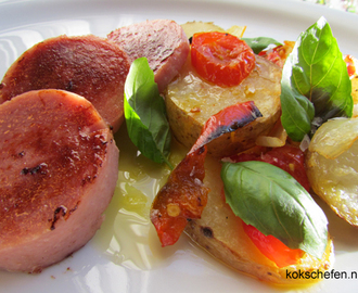 Medhelhavsinspirerad falukorv serverat med en ugnsstekt potatis med tomat, paprika och lök