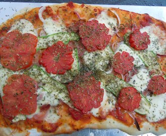 Hemgjord pizza med egenodlade tomater på toppen