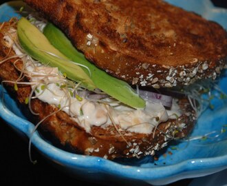 Smörgås fylld med böndipp, groddar, rödlök och avocado