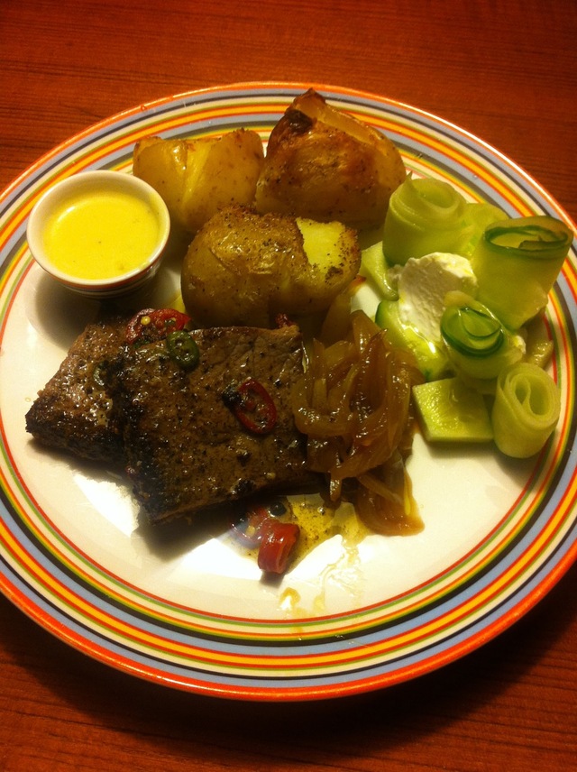 Steak af en slags med ovnbagte knuste kartofler, karameliseret løg i sukker og æblecidereddike, serveret med hollandaise og agurk i tykmælk.