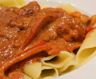 Kylling i tomat med bacon, tomat og røde peberfrugter på frisk pasta
