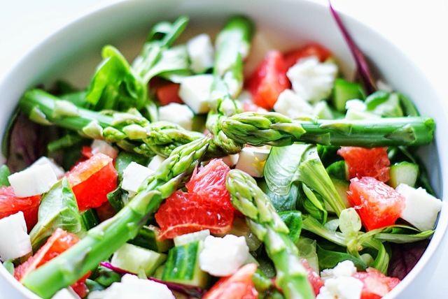 Frisk grøn salat med nye grønne asparges, rød grape og fetaost