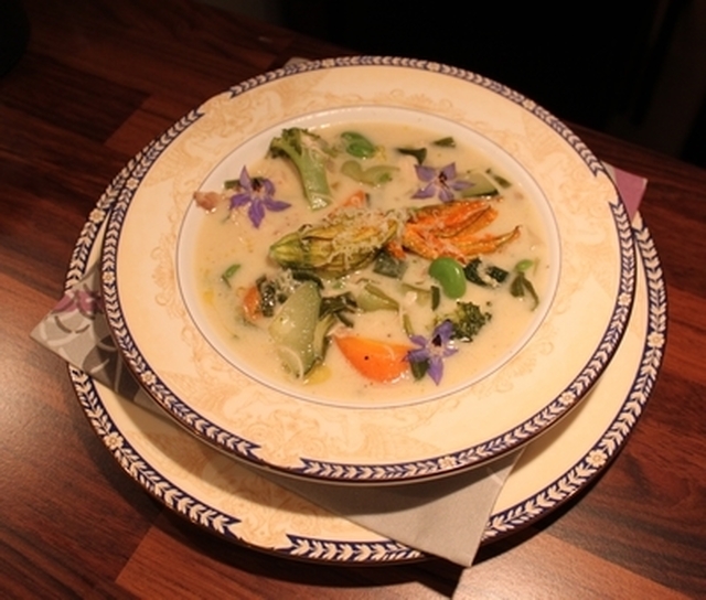 Kremet suppe med Ytterøykylling, økologiske grønnsaker, bondebønner og fylt squashblomst.