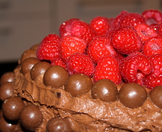Høy bursdagskake med sjokoladeostekrem og bringebær