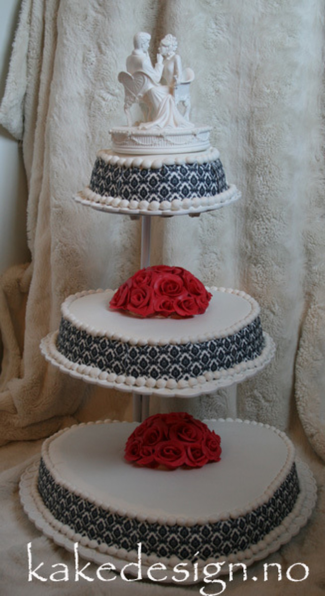 Bryllupskake med røde roser og damaskbord
