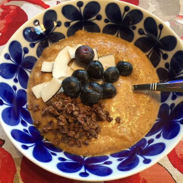 Supernyttig smoothiebowl med papaya, mandel, pistaschnötter, kokosvatten och chia - och med topping av raw kokos, kakaonibs och blåbär