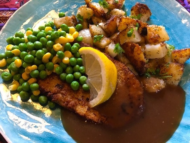 Schnitzel med stekt potatis och sås