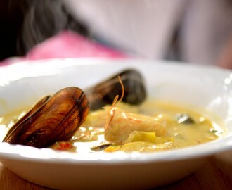 Fisksoppa med lax, havskatt, färska musslor, smaksatt  med saffran, curry, cayenne och ett stänk chili serveras med hembakad baguette