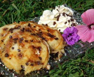 White and light chocolate chip pancakes with cinnamon cream and maple syrup