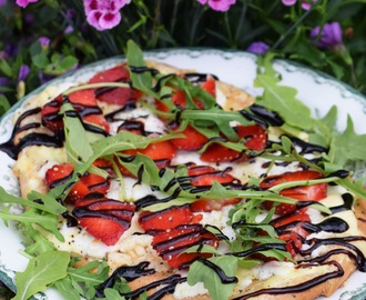 Vegetarisk pizza på naanbröd med getost, jordgubbar och ruccola