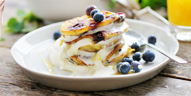 Amerikanska pannkakor med blåbär, lönnsirap och grädde