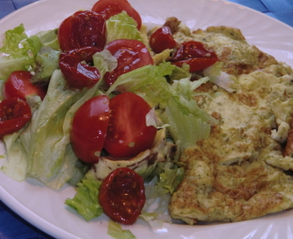 Latlunch med örtig omelett och sallad på avocado, och soltorkade körsbärstomater