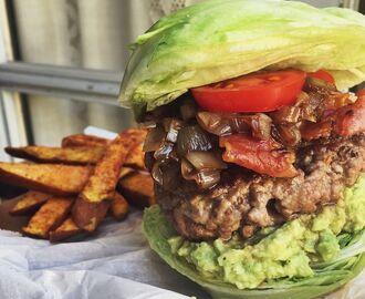 Saftig hamburgare i salladsbröd med bacon, guacamole och balsamico-karamelliserad lök